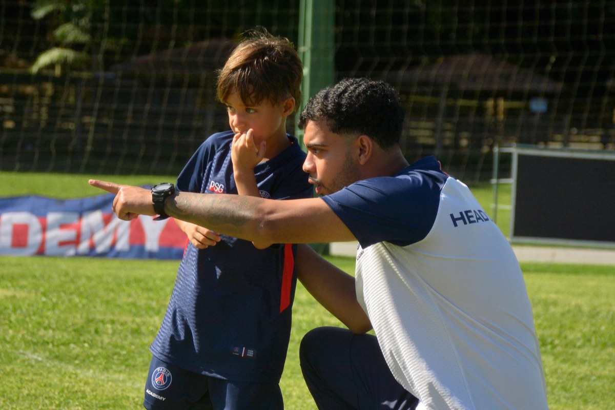 Professor da PSG Academy orientando um aluno durante o treino